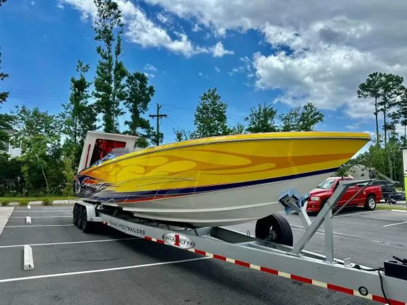Slide: The Image of 2005 Cigarette 39 Top Gun speedboat on trailer, vibrant yellow design, parked outdoors. - 3