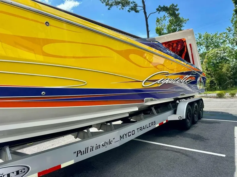 Slide: The Image of 2005 Cigarette 39 Top Gun boat with vibrant yellow and orange design on a Myco trailer. - 6