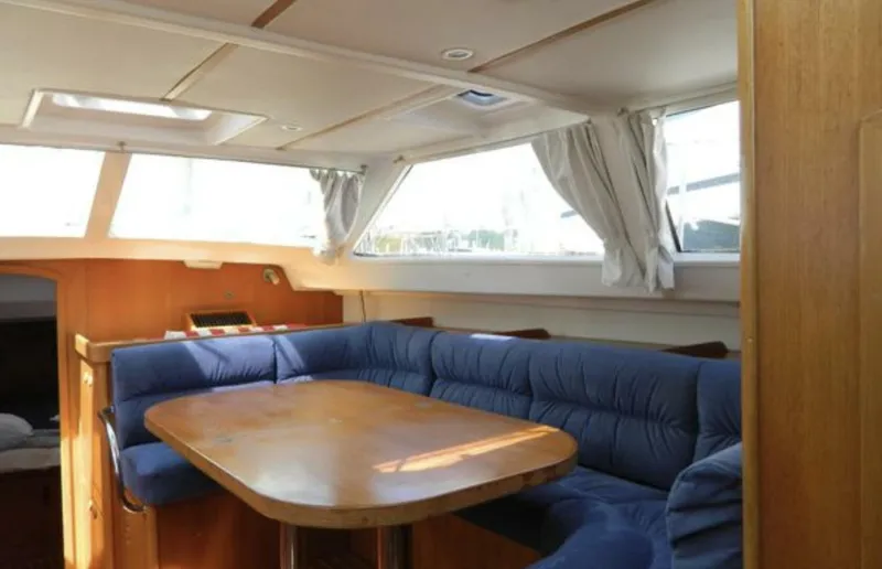 Slide: The Image of Interior of 2003 Wauquiez 40 Pilot Saloon with blue seating and wooden table. - 11