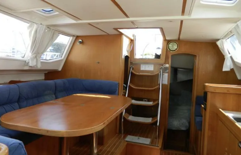 Slide: The Image of Interior of 2003 Wauquiez 40 Pilot Saloon with wooden dining area and blue seating. - 12