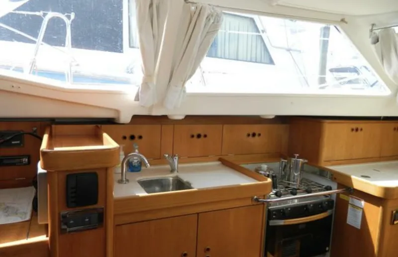 Slide: The Image of Interior of 2003 Wauquiez 40 Pilot Saloon yacht kitchen with wooden cabinetry and appliances. - 14
