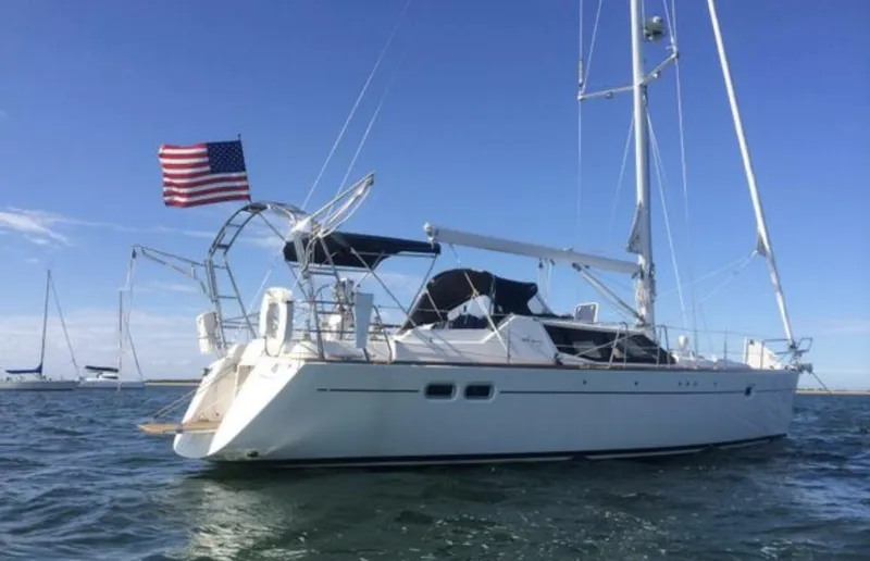 Slide: The Image of 2003 Wauquiez 40 Pilot Saloon yacht with American flag on open water. - 4