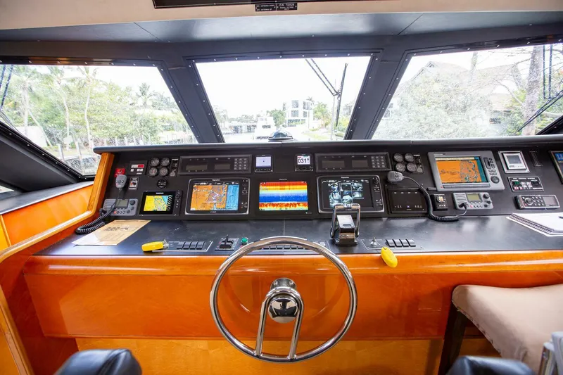 Slide: The Image of Control panel of a 1999 Tarrab Motor Yacht with navigation instruments and steering wheel. - 23