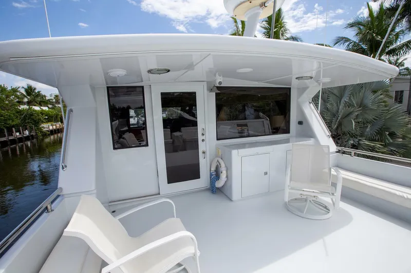 Slide: The Image of Tarrab 1999 motor yacht deck with seating, white exterior, and lush surroundings. - 29