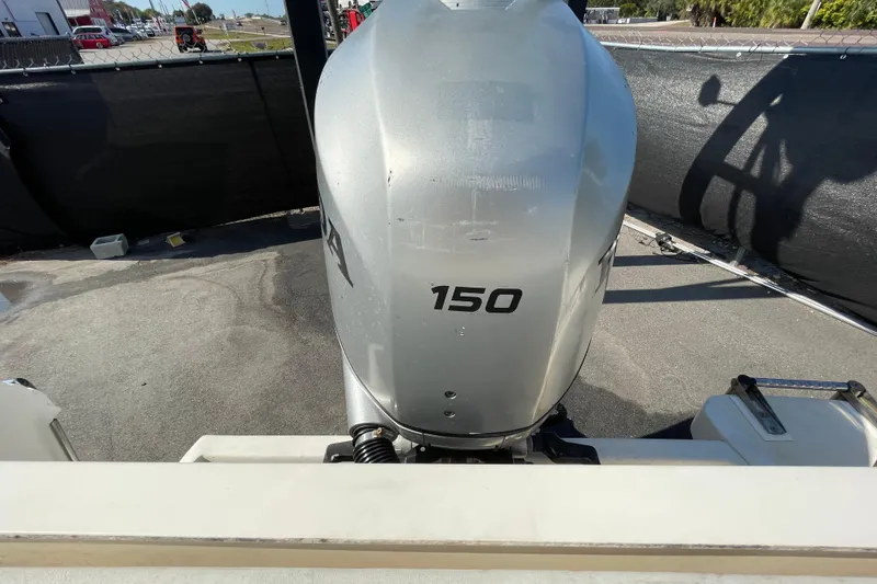 Slide: The Image of Silver outboard motor labeled "150" on a boat, parked on a sunny day. - 55