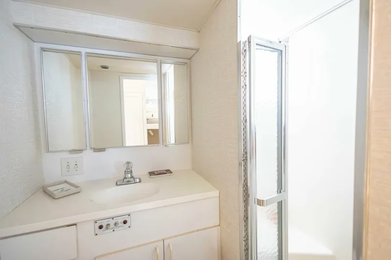 Slide: The Image of 1989 Hatteras Custom Cockpit bathroom with mirrored cabinet and shower. - 45
