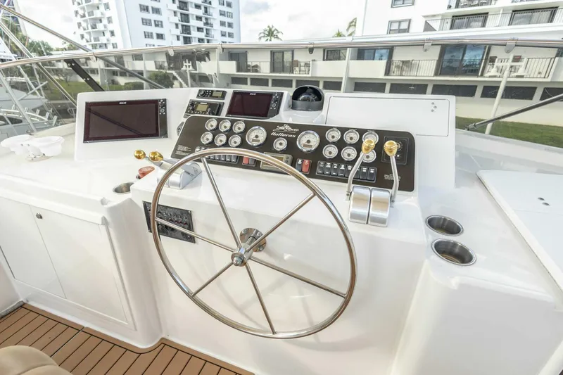 Slide: The Image of 1989 Hatteras Custom Cockpit helm with steering wheel, gauges, and controls. - 53