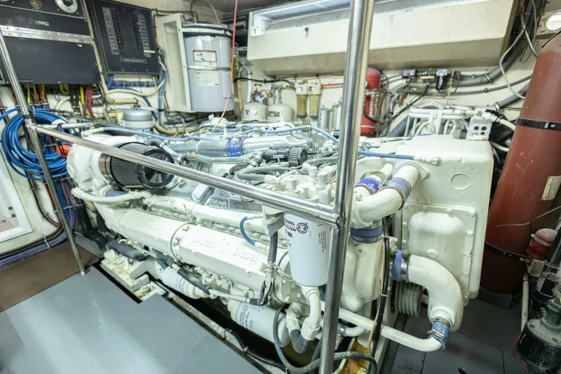 Slide: The Image of Engine room of 1989 Hatteras Custom Cockpit yacht, showcasing complex machinery and wiring. - 65