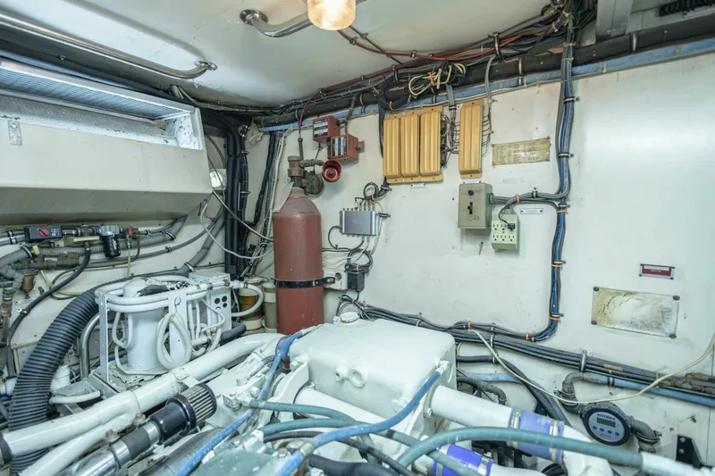 Slide: The Image of Engine room of 1989 Hatteras Custom Cockpit yacht, featuring complex wiring and machinery. - 68