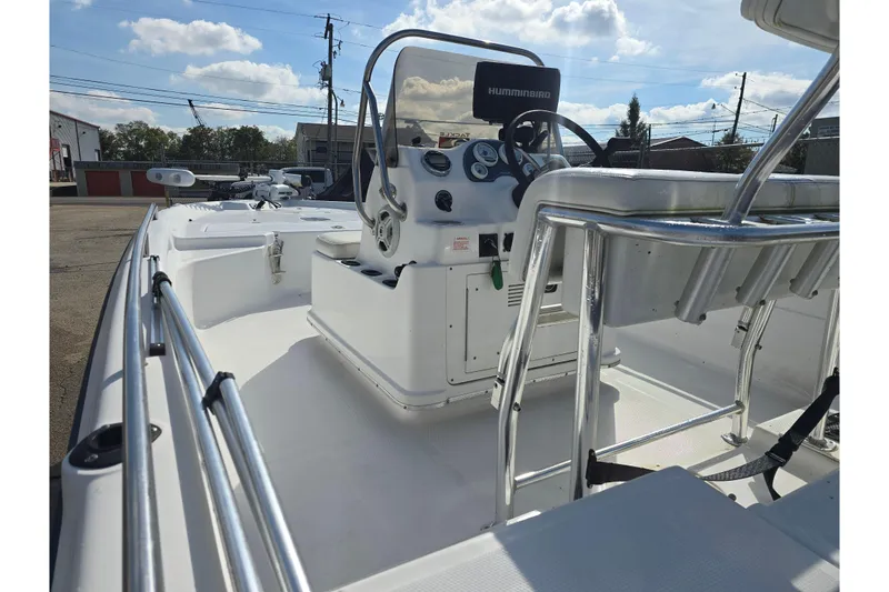 Slide: The Image of 2004 Fishmaster 1960 boat interior with steering console and seating under a sunny sky. - 11