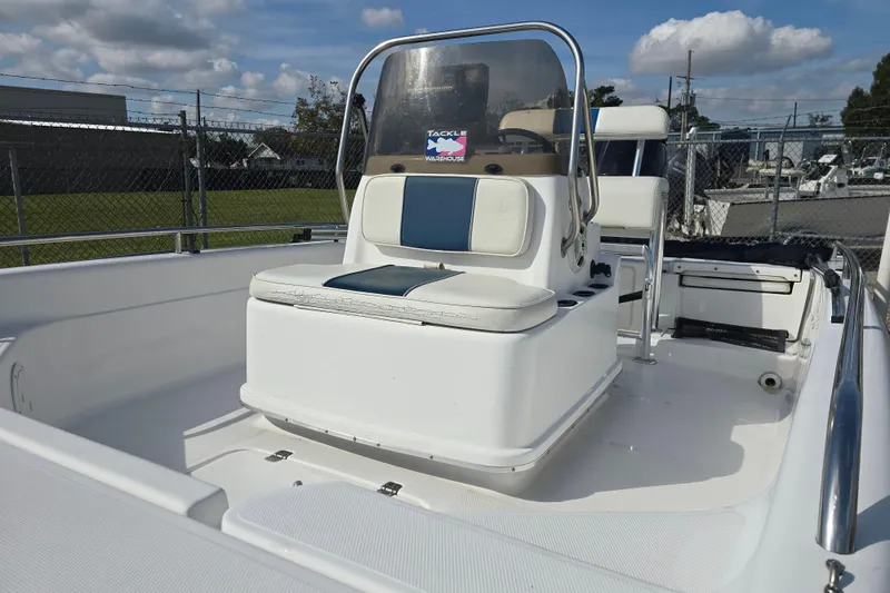 Slide: The Image of 2004 Fishmaster 1960 boat interior with seating and steering console under a cloudy sky. - 12