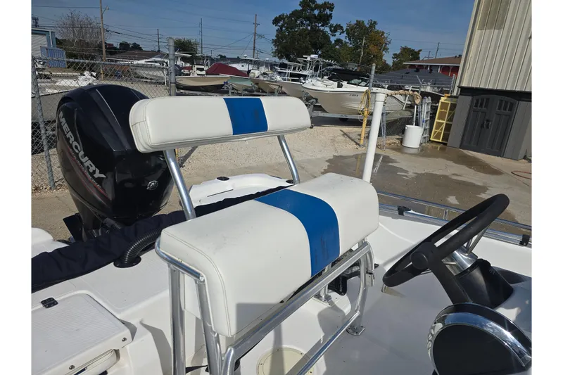 Slide: The Image of Fishmaster 1960 boat interior with Mercury engine, featuring white and blue seating, 2004 model. - 13