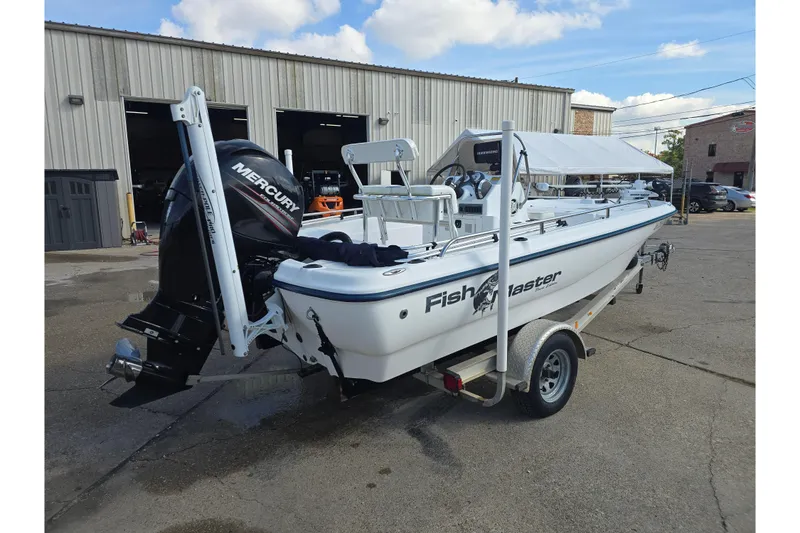 Slide: The Image of 2004 Fishmaster 1960 boat with Mercury engine on trailer, parked outside a warehouse. - 5