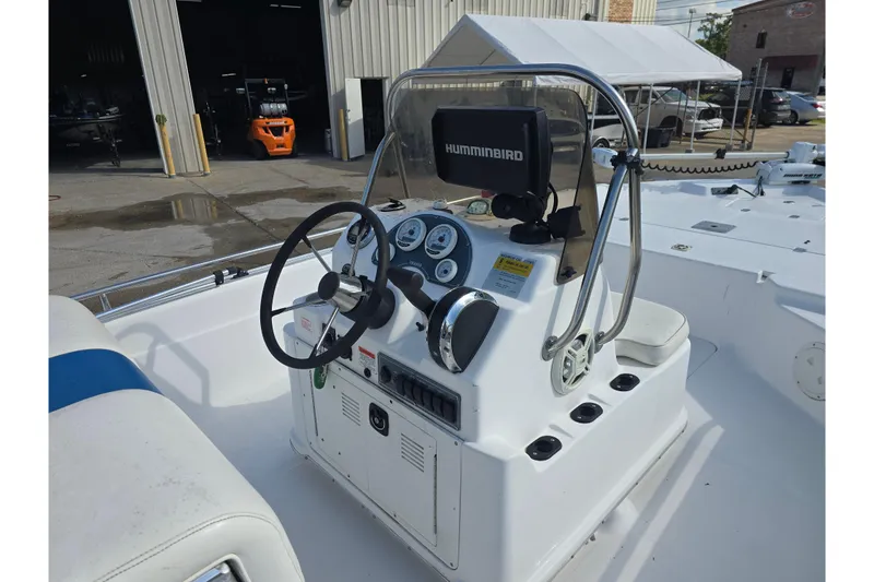 Slide: The Image of Center console of a 2004 Fishmaster 1960 boat with steering wheel and Humminbird display. - 6