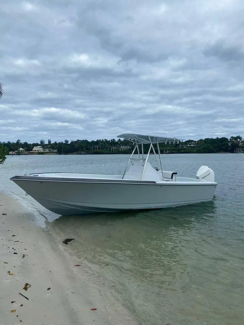 The Image of 1988 Intrepid 24 boat on a sandy beach with cloudy sky backdrop. - 1