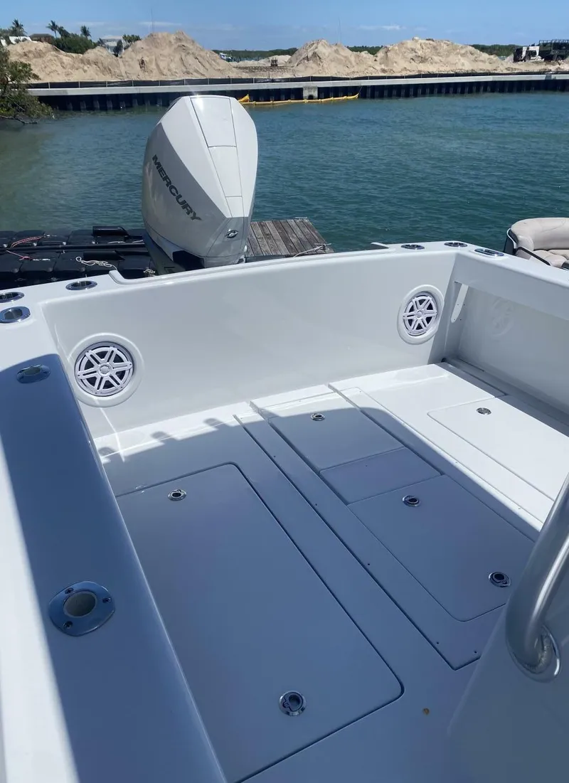 Slide: The Image of 1988 Intrepid 24 boat with Mercury outboard motor, docked by a scenic waterfront. - 11