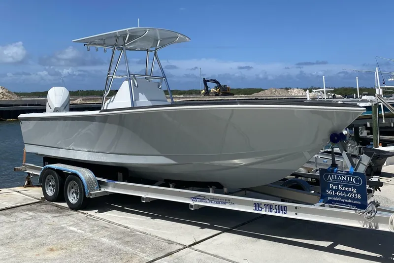 Slide: The Image of 1988 Intrepid 24 boat on trailer, docked by the water under a clear blue sky. - 13