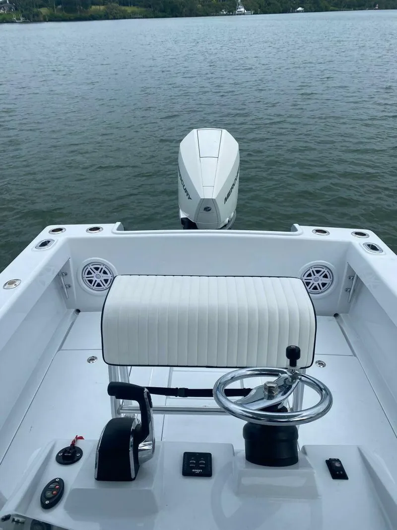 Slide: The Image of 1988 Intrepid 24 boat interior with steering wheel, seating, and outboard motor on calm water. - 6