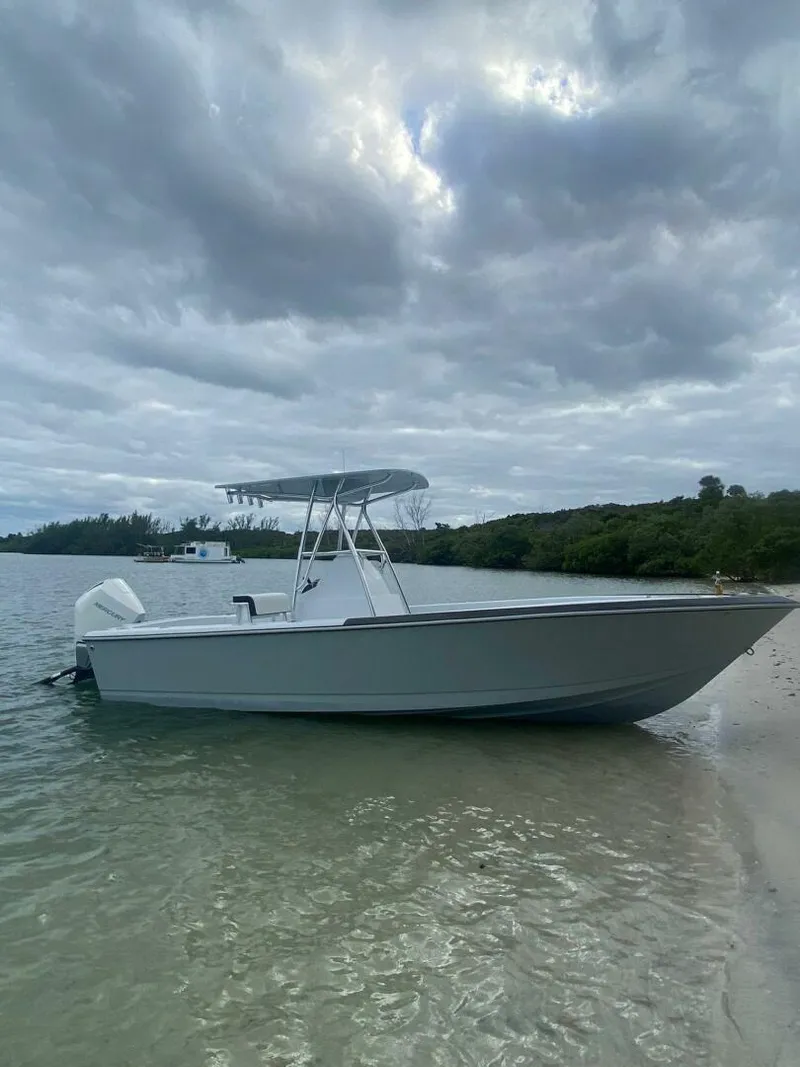 Slide: The Image of 1988 Intrepid 24 boat on a sandy shore under cloudy skies. - 8