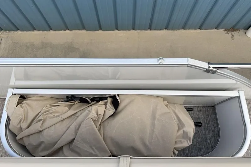 Slide: The Image of Storage compartment on a 2026 Godfrey Sweetwater 2286 SFLC boat, with beige cover inside. - 23