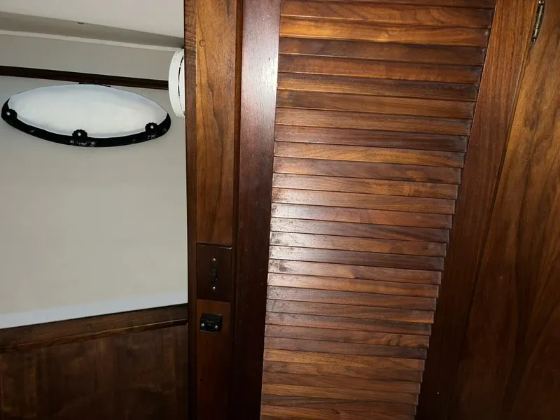 Slide: The Image of Wooden interior of 1987 Californian 42 Motor Yacht with louvered door and porthole. - 17
