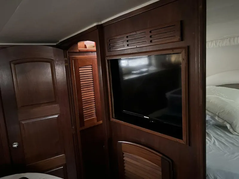 Slide: The Image of 1987 Californian 42 Motor Yacht interior with wood paneling and mounted TV. - 26