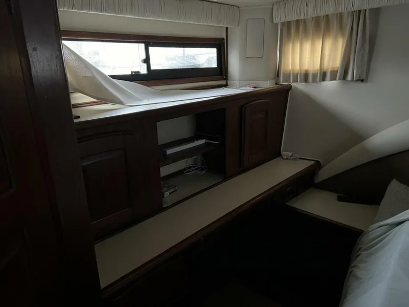 Slide: The Image of 1987 Californian 42 Motor Yacht interior with wooden cabinetry and window curtains. - 27