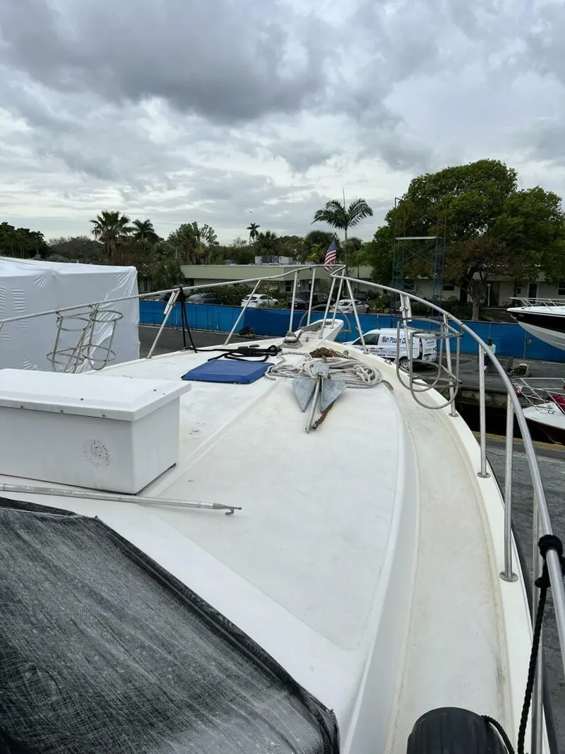 Slide: The Image of 1987 Californian 42 Motor Yacht on a cloudy day, docked with visible deck and railing. - 31