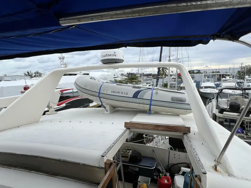 Slide: The Image of 1987 Californian 42 Motor Yacht with inflatable boat on deck, docked at marina. - 35