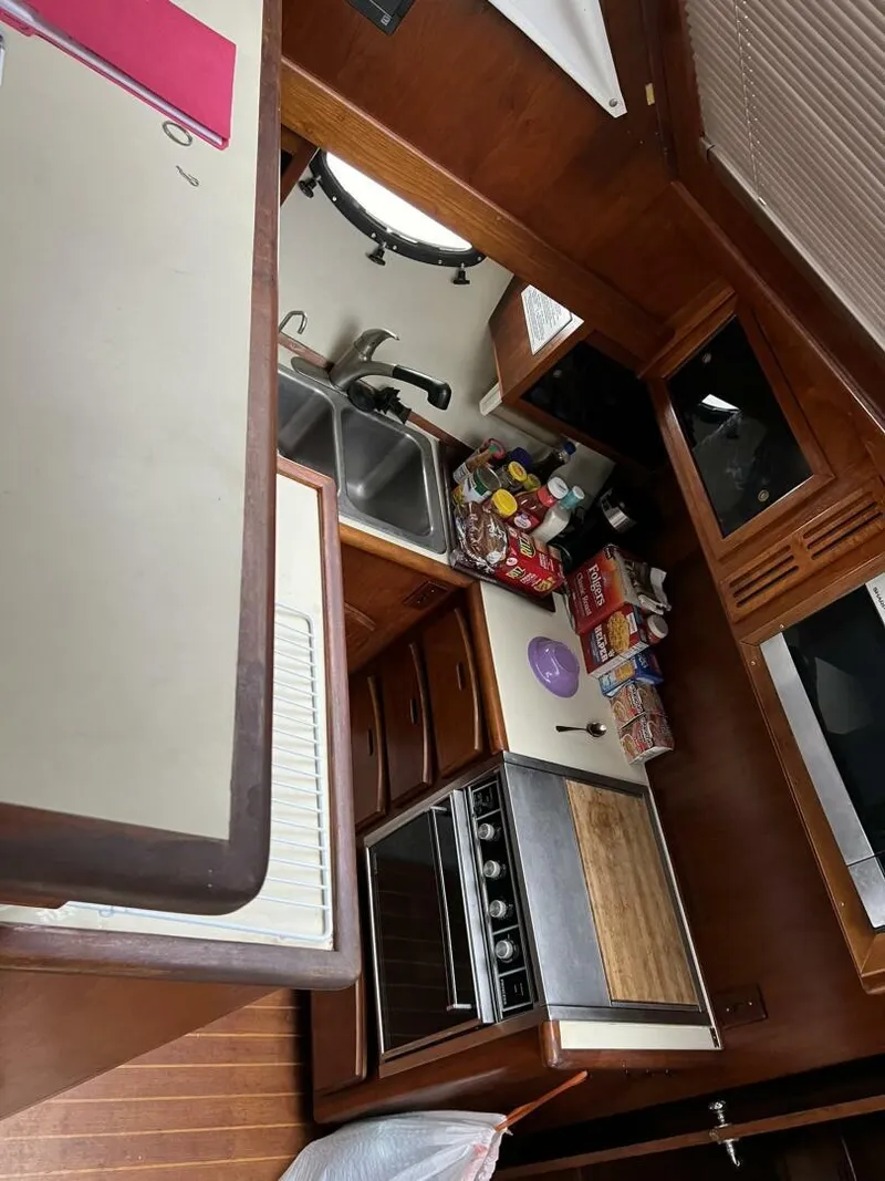 Slide: The Image of 1987 Californian 42 Motor Yacht kitchen with stove, sink, and wooden cabinetry. - 8