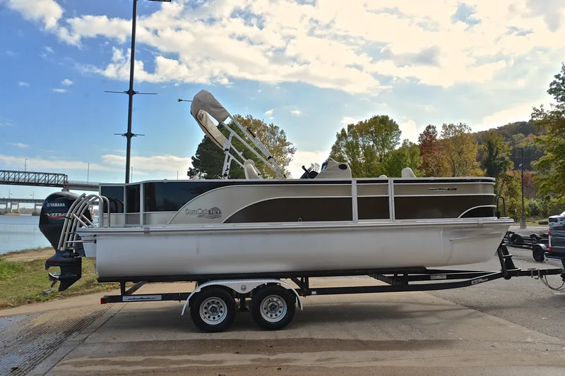 Slide: The Image of 2023 SunCatcher Select 22F pontoon boat on trailer by a scenic river. - 15