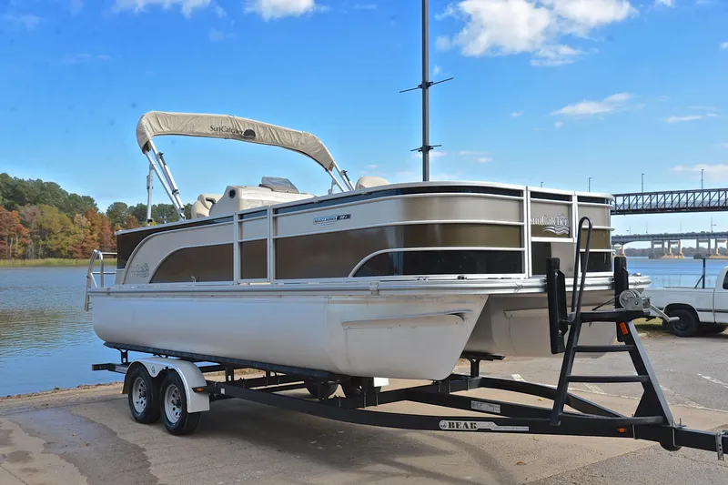 Slide: The Image of 2023 SunCatcher Select 22F pontoon boat on trailer by a lake. - 16