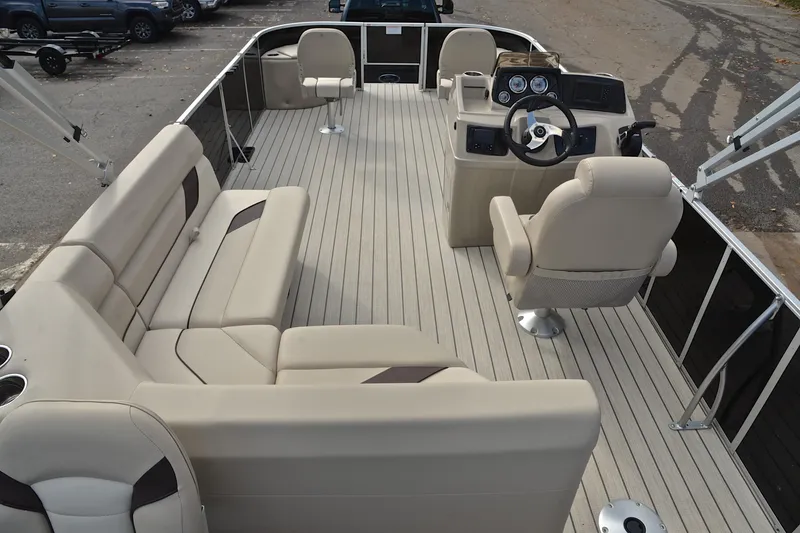 Slide: The Image of 2023 SunCatcher Select 22F pontoon boat interior with beige seating and steering console. - 18