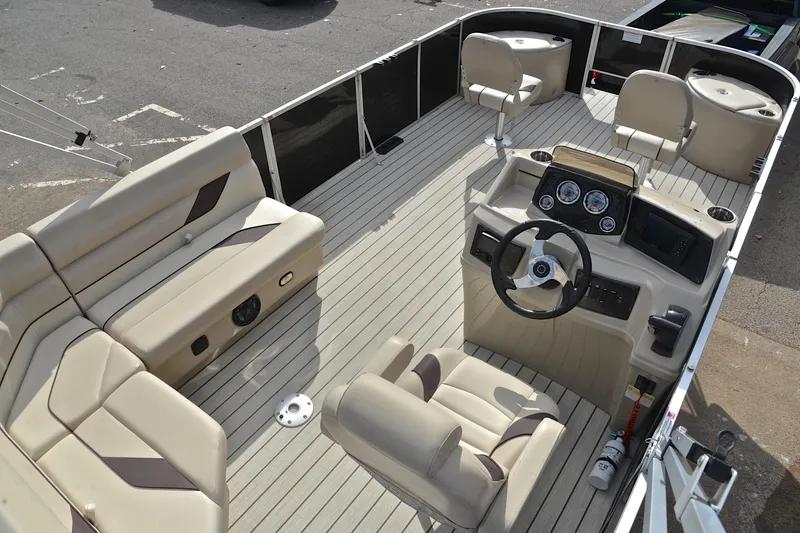 Slide: The Image of 2023 SunCatcher Select 22F pontoon boat interior with beige seating and modern dashboard. - 19
