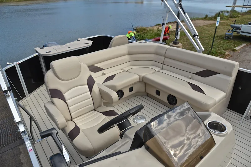 Slide: The Image of 2023 SunCatcher Select 22F pontoon boat interior with beige seating and steering console. - 22