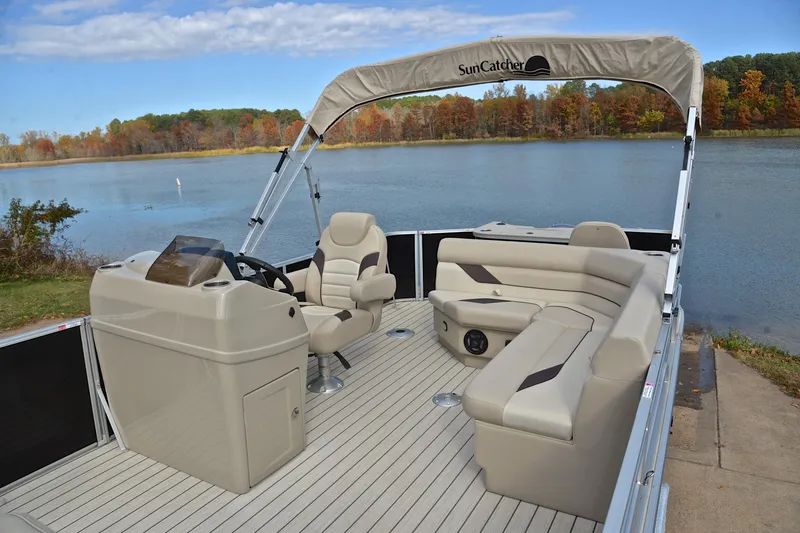 Slide: The Image of 2023 SunCatcher Select 22F pontoon boat interior by a scenic lake. - 23