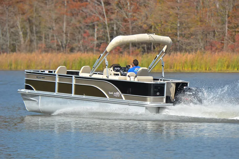 Slide: The Image of 2023 SunCatcher Select 22F pontoon boat cruising on a scenic lake. - 4