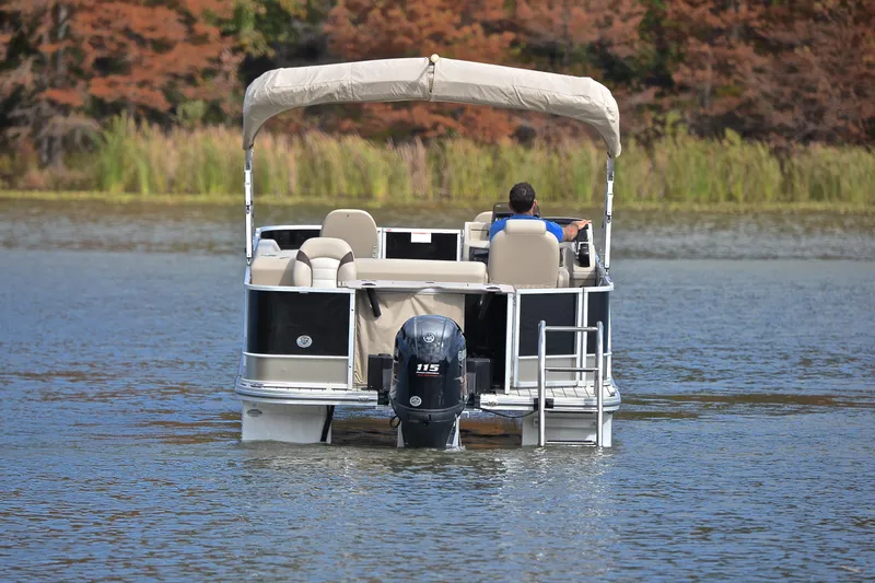 Slide: The Image of 2023 SunCatcher Select 22F pontoon boat cruising on a serene lake. - 7