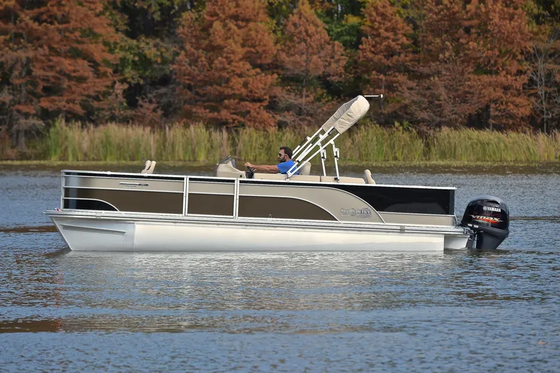 Slide: The Image of 2023 SunCatcher Select 22F pontoon boat cruising on a serene lake. - 8