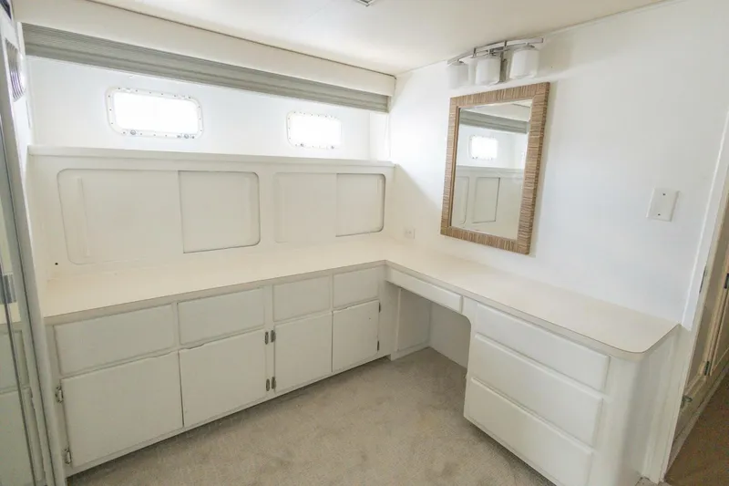 Slide: The Image of Interior of 1987 Hatteras 70 Cockpit Motor Yacht with white cabinetry and mirror. - 19