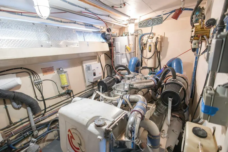 Slide: The Image of Engine room of 1987 Hatteras 70 Cockpit Motor Yacht, showcasing mechanical components and wiring. - 38