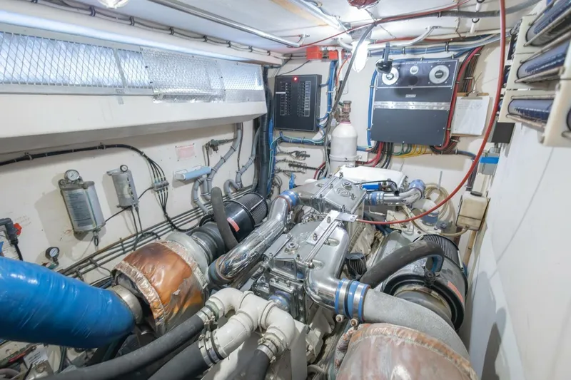 Slide: The Image of Engine room of 1987 Hatteras 70 Cockpit Motor Yacht, showcasing mechanical components and wiring. - 47