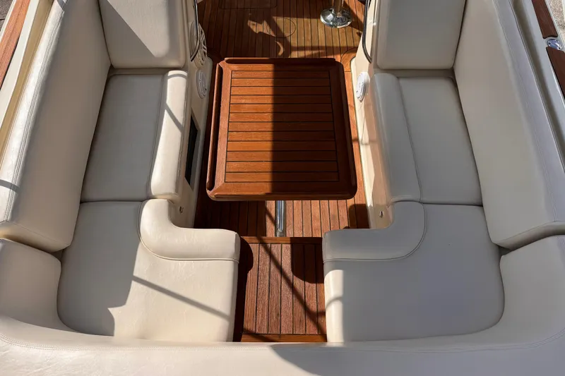 Slide: The Image of 2014 Chris-Craft Launch 28 interior with beige seating and wooden table. - 10