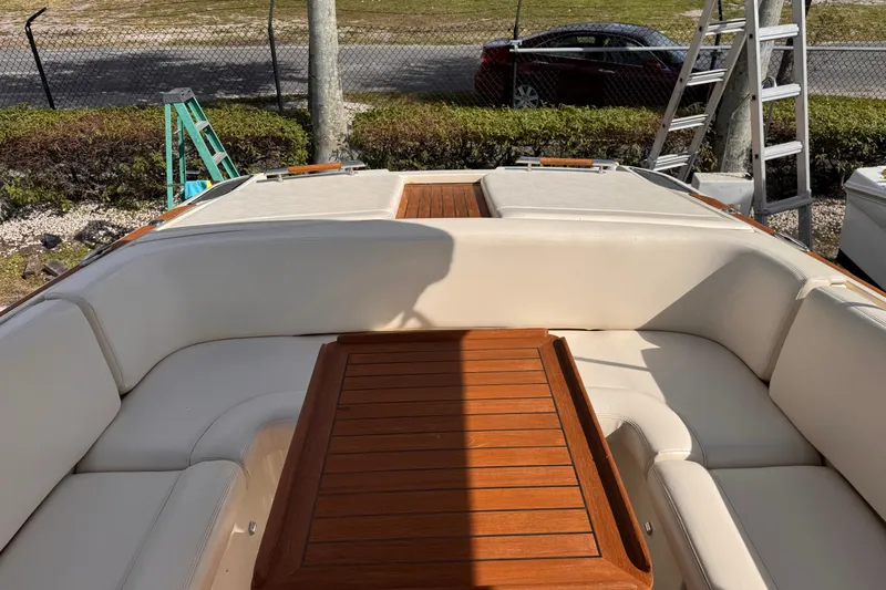 Slide: The Image of 2014 Chris-Craft Launch 28 boat interior with wooden table and white seating. - 11