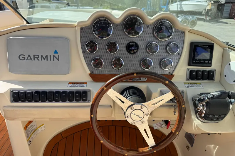 Slide: The Image of 2014 Chris-Craft Launch 28 dashboard with Garmin navigation and wooden steering wheel. - 12