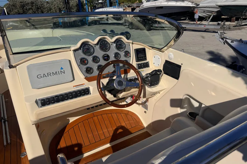 Slide: The Image of 2014 Chris-Craft Launch 28 boat dashboard with Garmin navigation system and wooden steering wheel. - 14