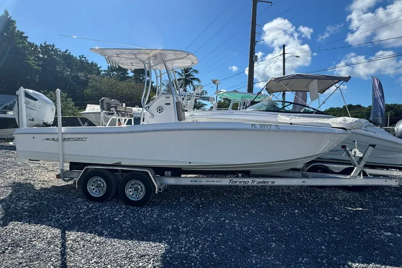 The Image of 2022 Aquasport 230 Pro Bay boat on trailer under clear blue sky. - 0