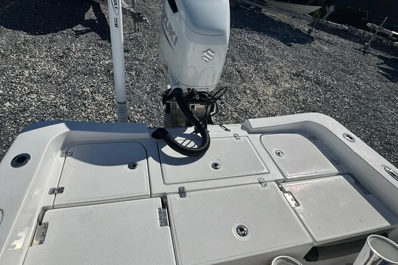 Slide: The Image of 2022 Aquasport 230 Pro Bay boat with Suzuki outboard motor and storage compartments. - 10