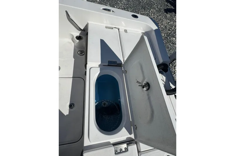Slide: The Image of 2022 Aquasport 230 Pro Bay boat storage compartment with open lid. - 12
