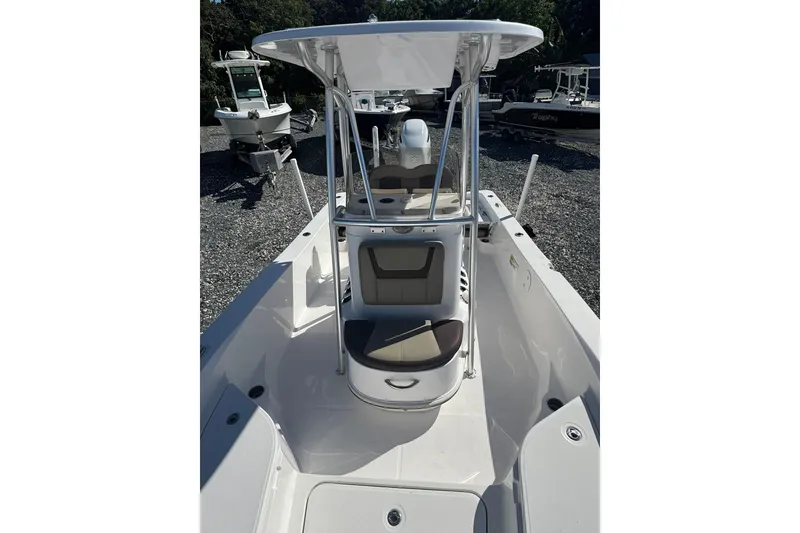 Slide: The Image of 2022 Aquasport 230 Pro Bay boat with T-top and seating, displayed outdoors. - 2